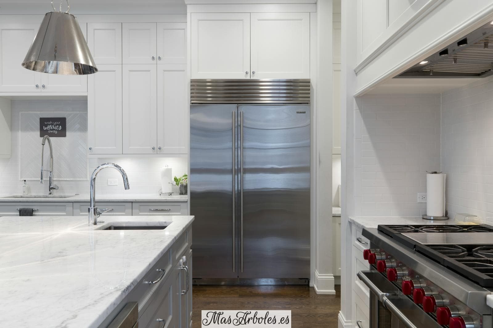 Stainless Steel Refrigerator Beside White Kitchen Cabinet